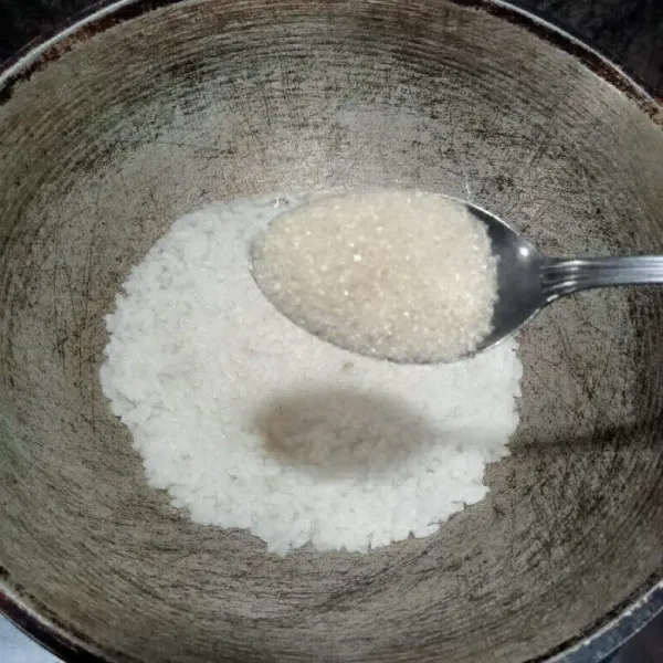 Tambahkan gula pasir dan aduk rata, kemudian ratakan nasi.