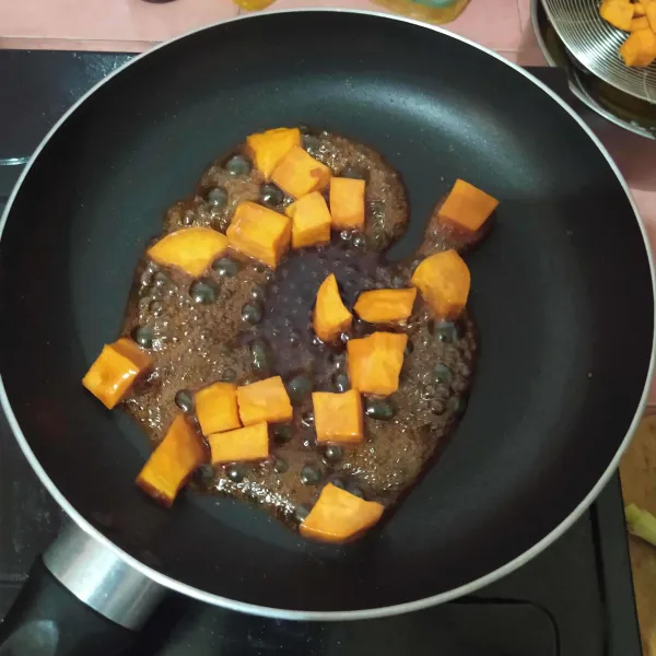 Masukkan ubi goreng, lalu aduk rata. Kemudian taburi dengan wijen sangrai dan sajikan.