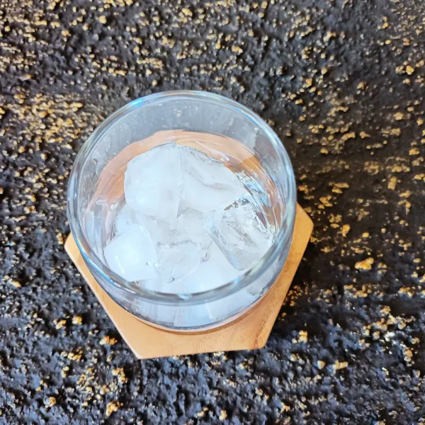 Siapkan gelas lalu tambahkan es batu.