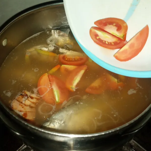 Masukkan tomat, garam dan kaldu bubuk. Masak selama 7-10 menit supaya ikan benar-benar matang dan kaldunya keluar. Koreksi rasa. Matikan api.