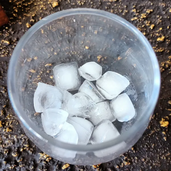 Siapkan gelas saji, masukkan es batu.