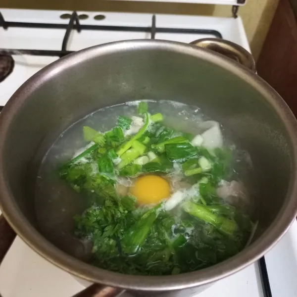 Masukan irisan bawang daun, seledri dan telur ayam, aduk cepat.