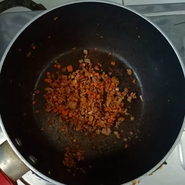 Masukan daging cincang dan wortel kedalam tumisan bawang. Tambahkan sedikit gula dan garam. Aduk hingga semua bahan tercampur dan daging matang.