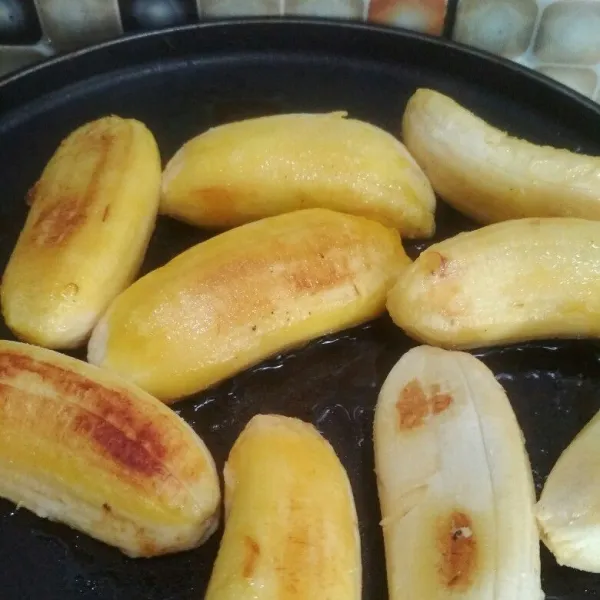 Panaskan teflon beri margarin secukupnya panggang pisang hingga kecoklatan kedua sisi, bagi menjadi dua memanjang, sisihkan