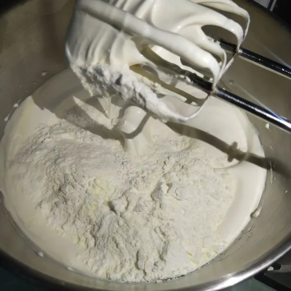 Setelah kental berjejak kemudian masukkan tepung terigu susu bubuk dan baking powder lalu mixer dengan kekuatan rendah hingga tercampur rata.