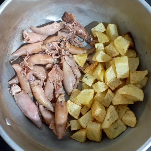 Cuci bersih cumi lalu rebus sampai mendidih kemudian angkat dan tiriskan, potong kentang bentuk kotak lalu goreng kemudian angkat dan sisihkan.