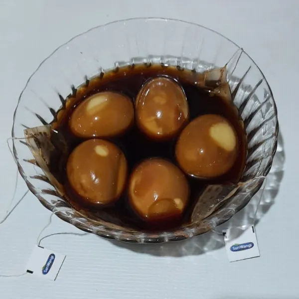 Rendam telur rebus dengan seduhan teh selama 1 jam / hingga permukaanya coklat.