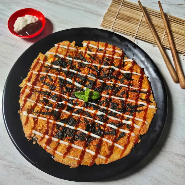Letakkan okonomiyaki diatas piring saji kemudian taburi dengan Nori dan boncabe serta beri saus dan mayonaise. Dan siap disajikan.