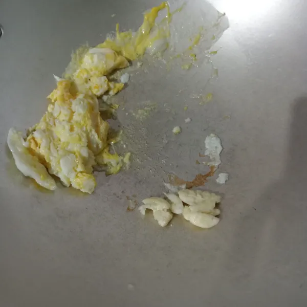 Goreng telur orak-arik, sisihkan, lalu masukkan bawang putih dan tumis sampai harum.