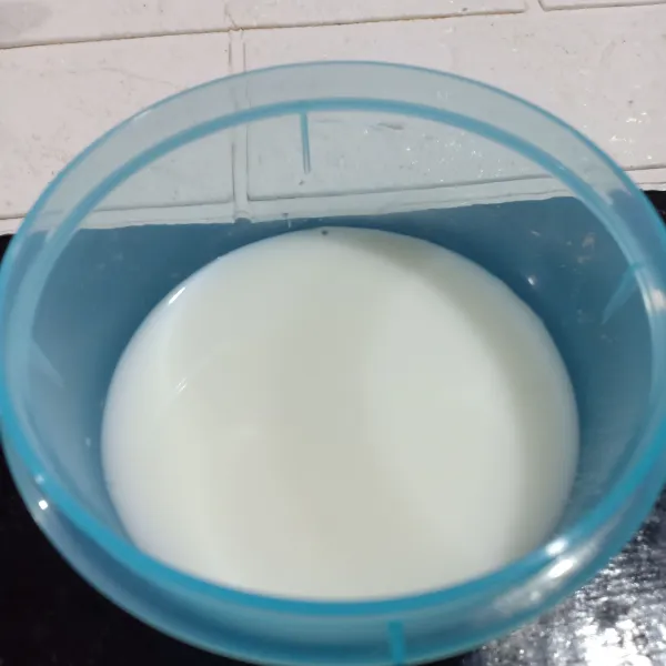 Campur susu cair dan simpel sirup dalam mangkuk.