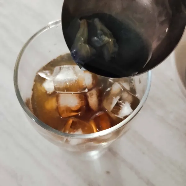 Kemudian beri es batu, dan tuangkan teh bunga telang secara perlahan dan siap disajikan.