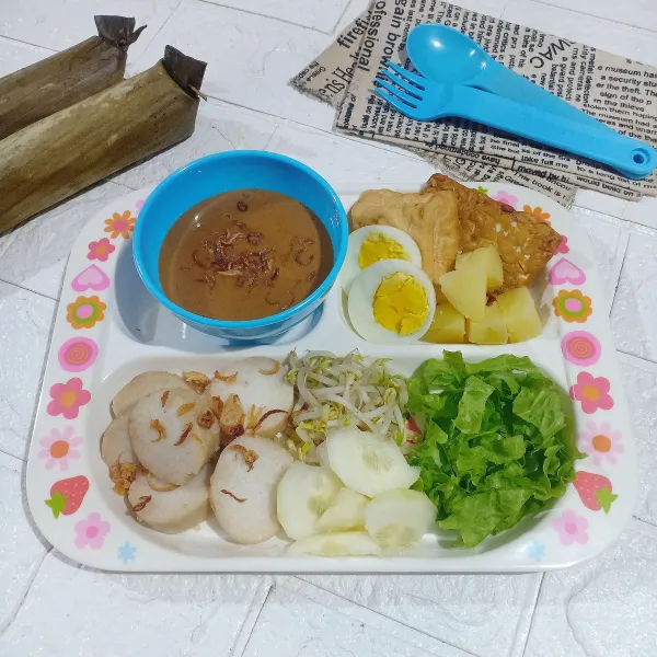 Sajikan lontong dan pelengkapnya di piring saji.