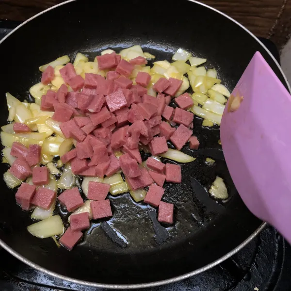 Masukkan bawang putih dan sosis/daging burger sapi. Goreng hingga daging berwarna sedikit gelap.