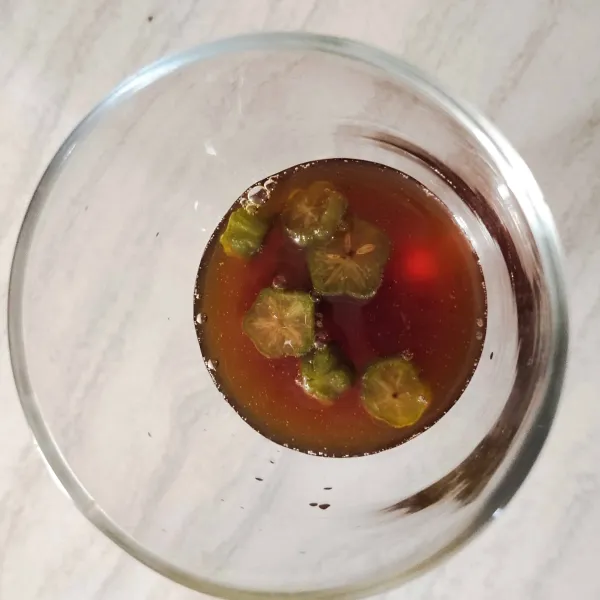 Siapkan gelas saji, masukkan sirup belimbing wuluh dan juga buah belimbingnya.