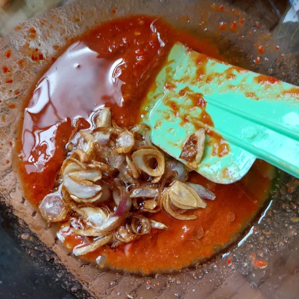 Goreng bawang hingga kering, lalu tuang ke adonan sambal berikut minyaknya selagi masih panas, aduk rata.