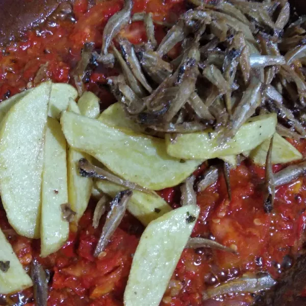 Campur ikan teri dan kentang, aduk rata. Sajikan.