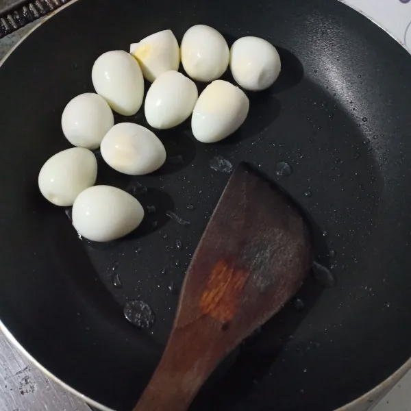 Rebus telur puyuh, kupas, lalu goreng dengan sedikit minyak.