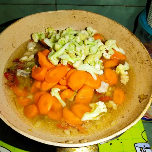 Kemudian masukkan irisan wortel brokoli dan daging ayam yang sudah dibersihkan, cincang lalu tambahkan air secukupnya lalu aduk sampai rata.