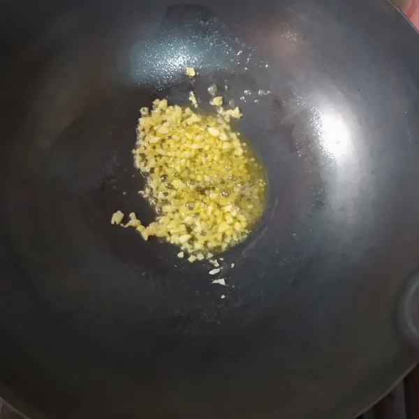Panaskan margarin, lalu tumis bawang putih cincang hingga harum.