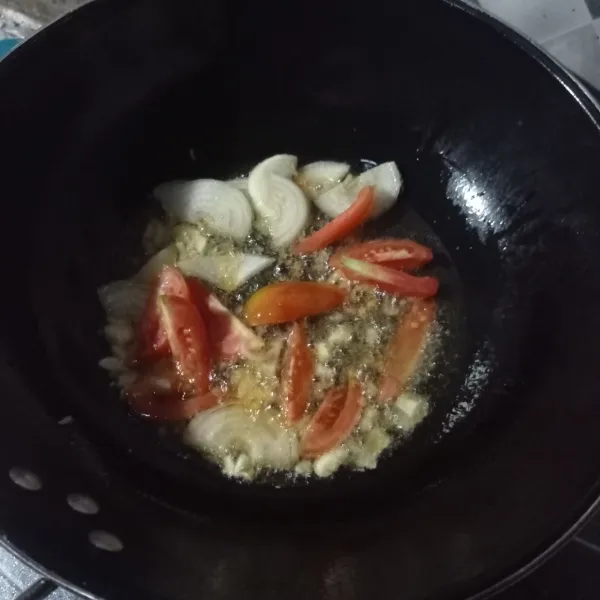 Tumis bawang putih, bawang Bombay dan tomat sampai matang.