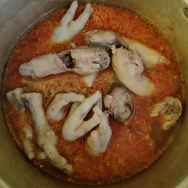 Masukkan kepala dan ceker ayam, lalu aduk rata. Masak hingga mendidih dan cicipi rasanya.