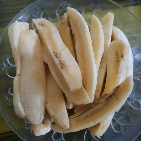 Kupas pisang, kemudian belah menjadi 4 bagian setiap buahnya.