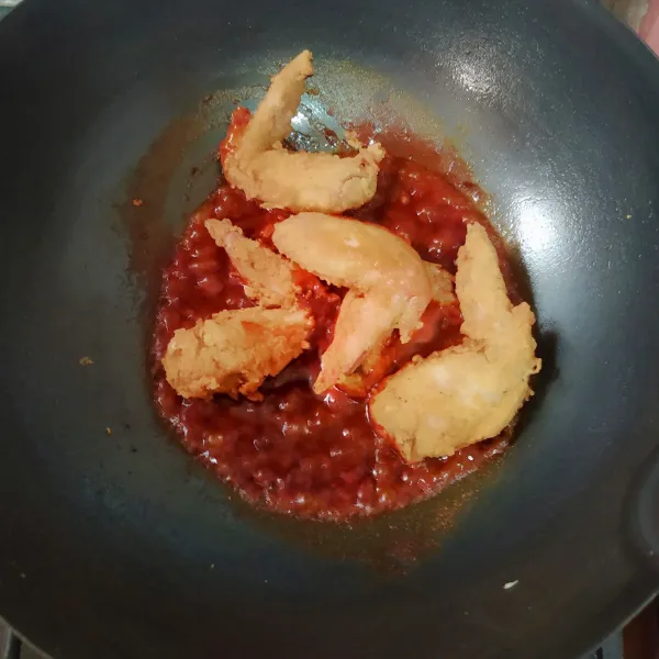 Masukkan ayam goreng dan aduk sampai ayam terbalut bumbu, kemudian sajikan dengan taburan wijen sangrai.
