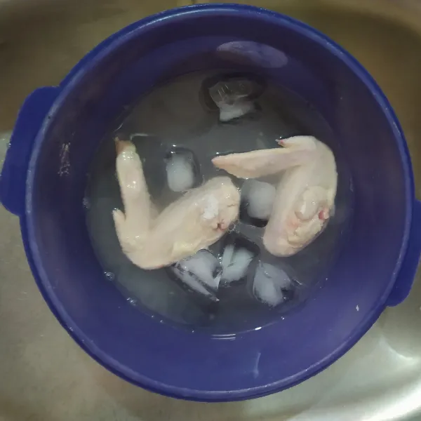 Lalu celup ayam di air dingin berisi es batu.