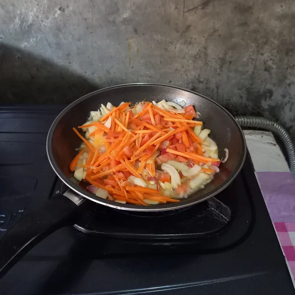 Tumis bawang merah, bawang putih, dan bawang bombay sampai harum dan layu. Masukkan air, wortel dan tomat. Masak sampai wortel matang.