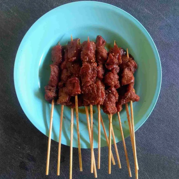 Tusuk daging menggunakan tusuk sate.