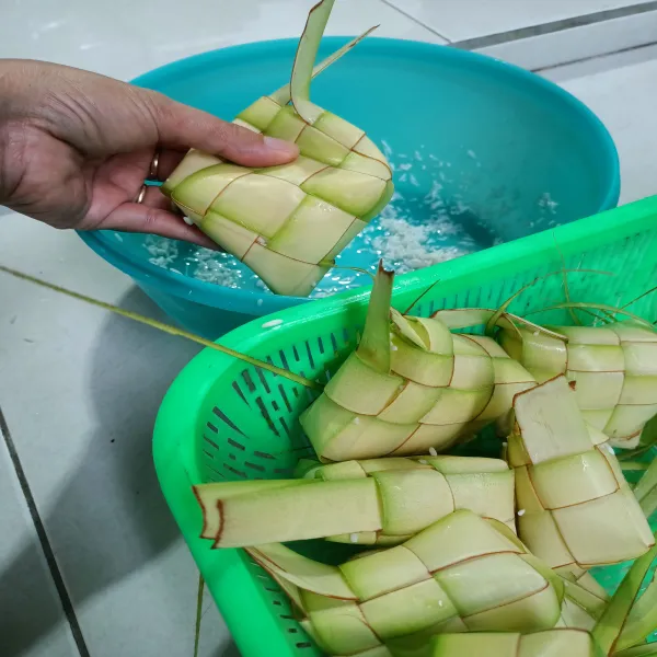 Isi ketupat dengan beras sampai sebanyak 3/4 bagian.