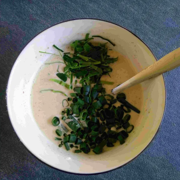 Masukkan irisan daun jeruk dan daun bawang lalu aduk rata.