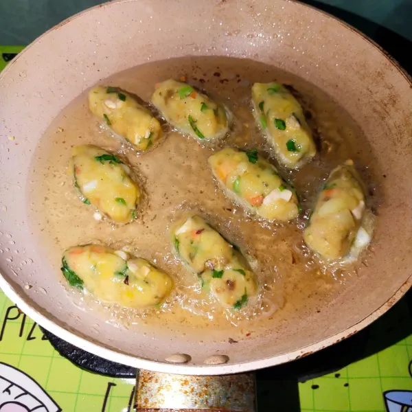 Goreng perkedel ayam hingga matang dan siap disajikan.