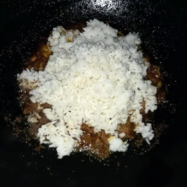 Masukkan nasi, aduk-aduk sampai tercampur rata dengan bumbu dan daging.