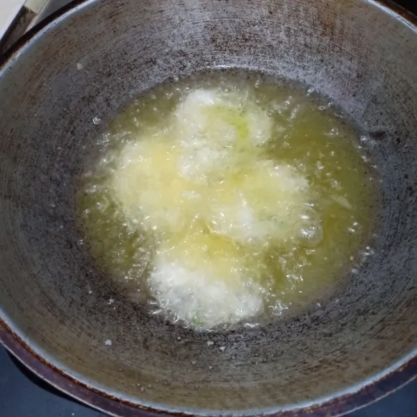 Goreng cireng dalam wajan berisi minyak goreng.