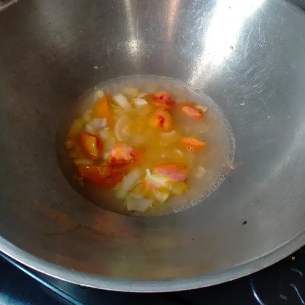 selanjutnya masukkan air dan irisan tomat.