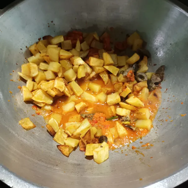Lalu panaskan minyak, tumis bumbu halus, daun salam dan daun jeruk sampai matang. Kemudian masukan kentang, ati ampela dan air. Aduk.