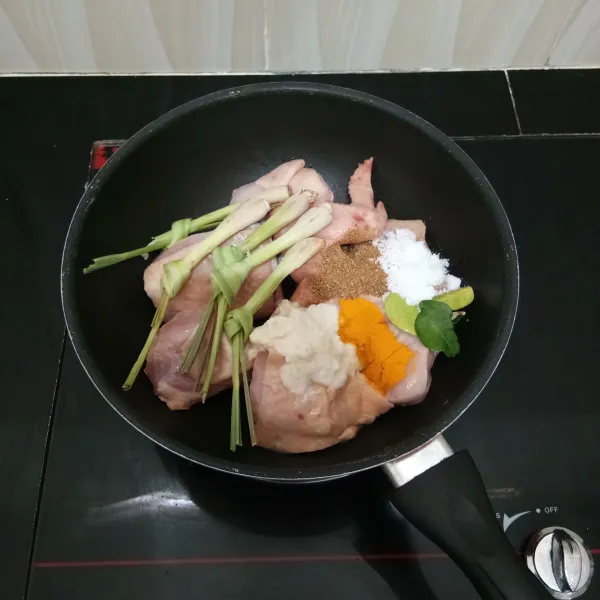 Masukkan ayam ke dalam panci. Tambahkan bumbu halus, serai, ketumbar bubuk, kunyit bubuk, daun jeruk dan garam.