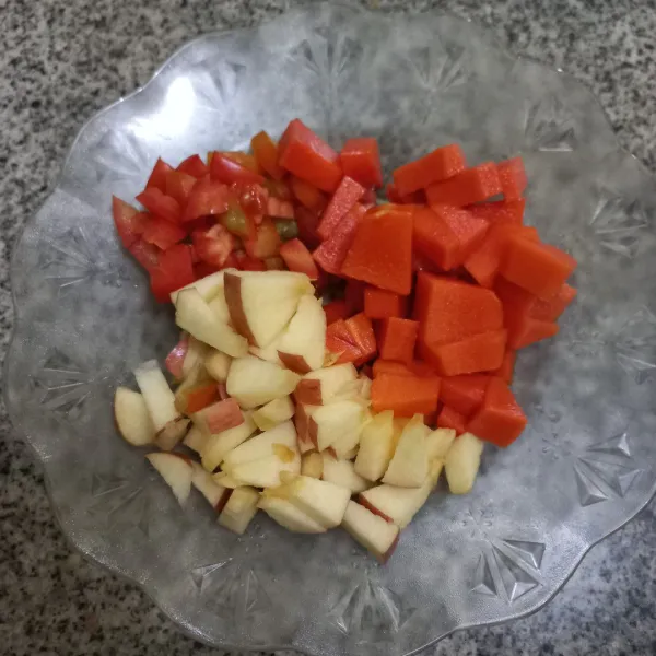 Kupas pepaya lalu potong dadu pepaya, apel dan tomat