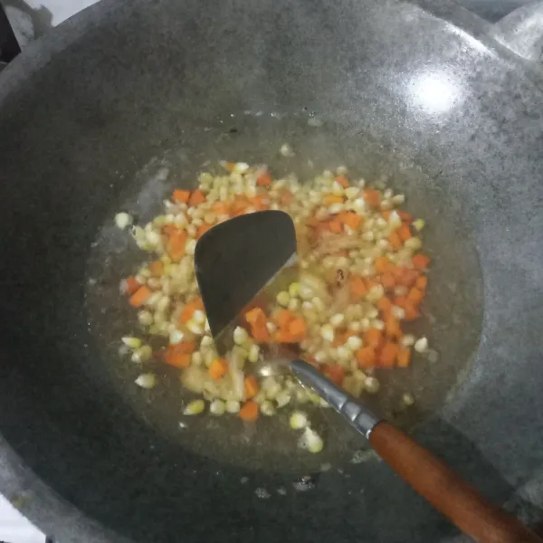 Tuang air, biarkan mendidih lalu masukkan wortel dan jagung manis. Masak hingga setengah empuk.