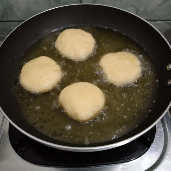 Goreng donat hingga matang di kedua sisi dengan api panas tapi kecil, setelah matang, tiriskan.