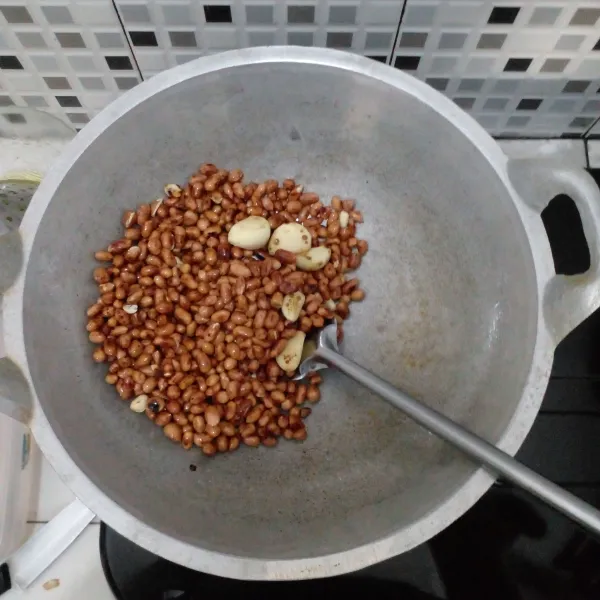 Goreng kacang tanah dan bawang putih menggunakan wajan tanpa minyak goreng.