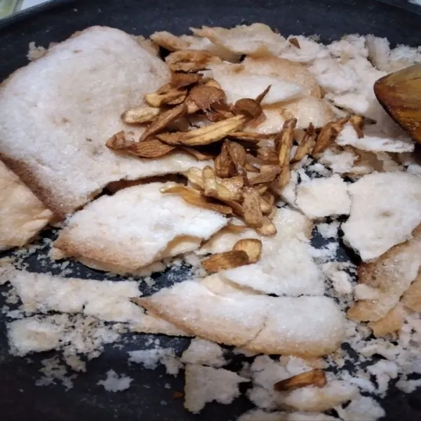 Campur kerupuk udang yang telah digoreng, bawang putih goreng dan rebon yang telah disangrai terlebih dahulu di atas cobek besar.