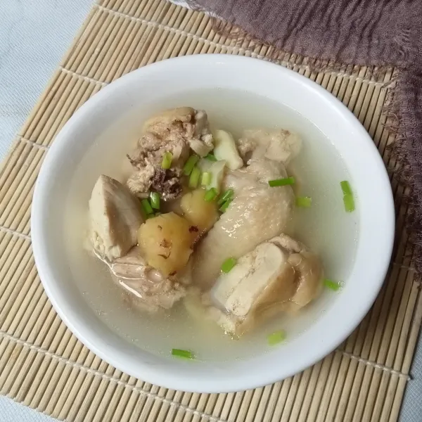 Sajikan ayam rebus dengan taburan daun bawang.