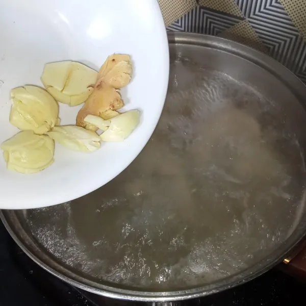 Setelah mendidih, masukkan bawang putih dan jahe.