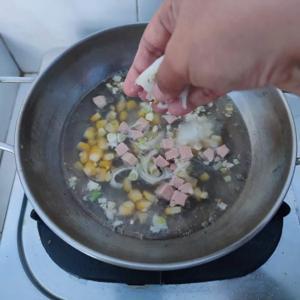 Ketika mulai empuk masukkan potongan sosis dan bawang bombay.