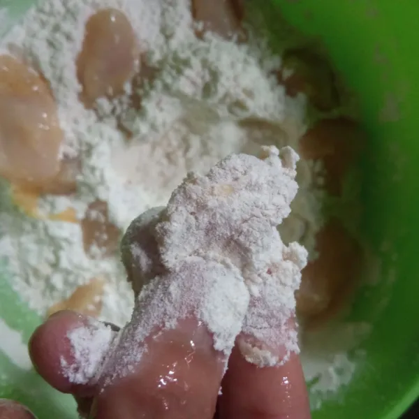Baluri ayam satu per satu ke tepung kering hingga semua permukaannya tertutupi.