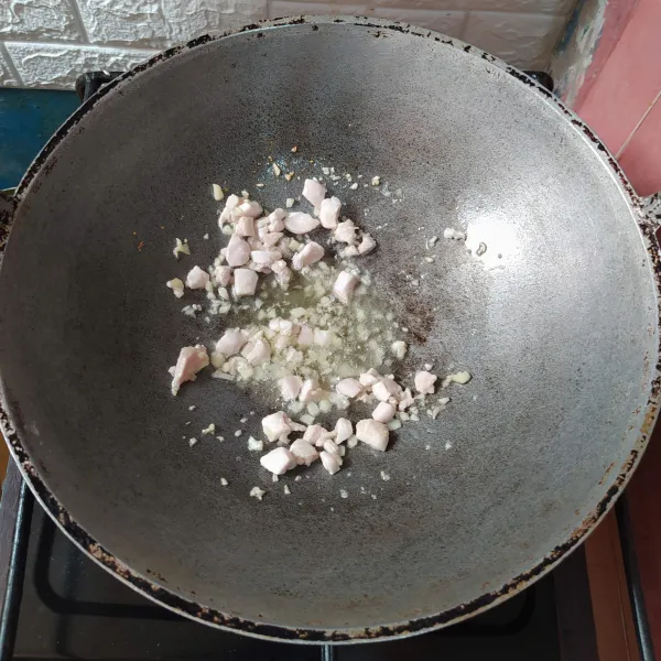 Tumis bawang putih hingga harum.
Masukkan ayam cincang, aduk rata sampai berubah warna.