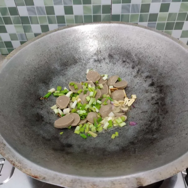 Kemudian masukkan bakso dan daun bawang, tumis hingga layu.