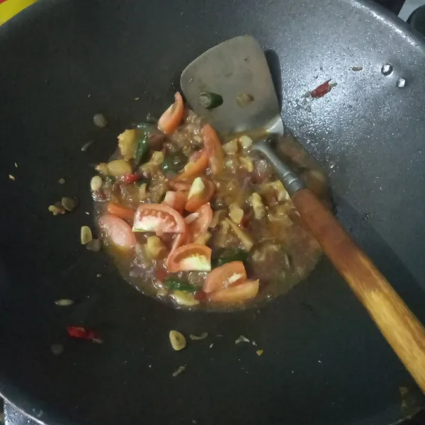 Tambahkan tomat, masak hingga air hampir habis. Tes rasa.
